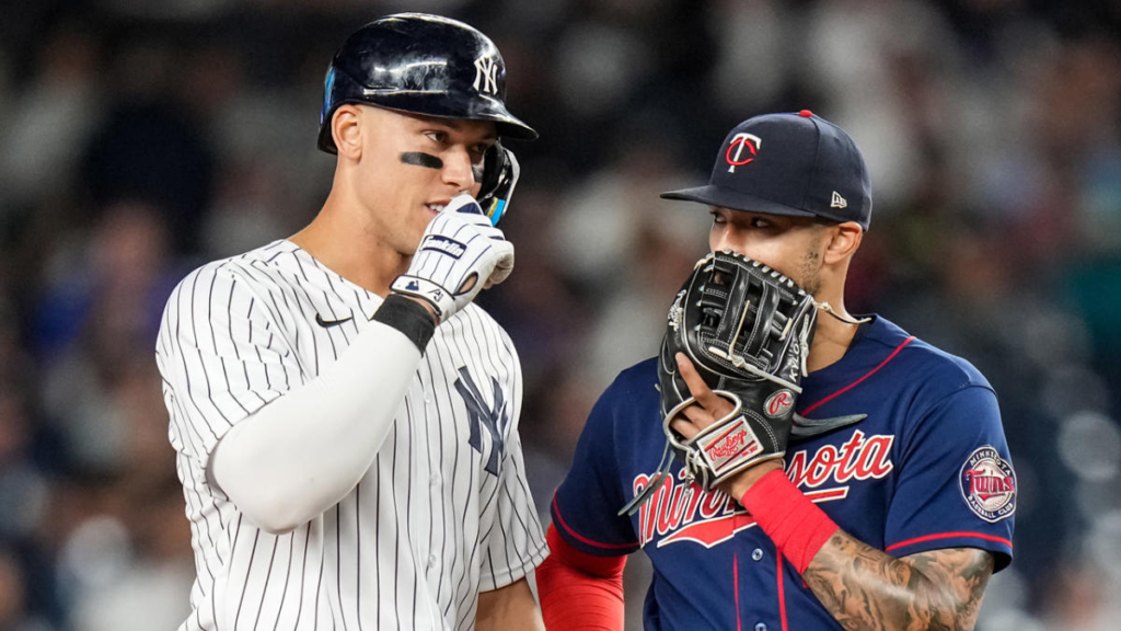 Aaron Judge is talking to Carlos Correa during a Yankees' game against the Twins in Yankee Stadium.