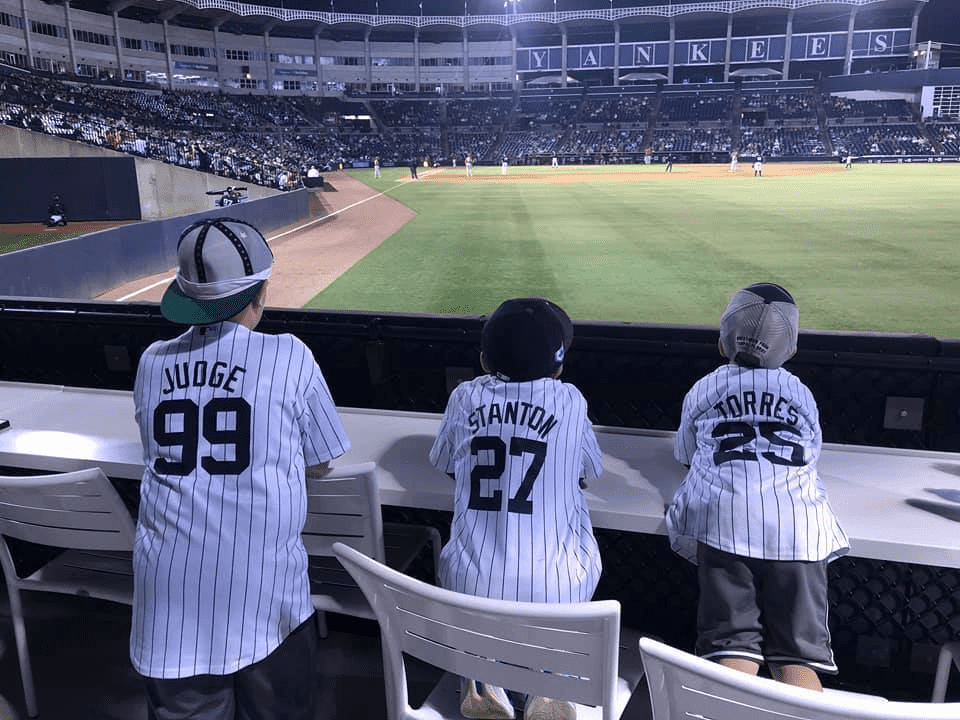 Three kids were watching Yankees spring training at George M. Steinbrenner Field, Tampa, Florida.