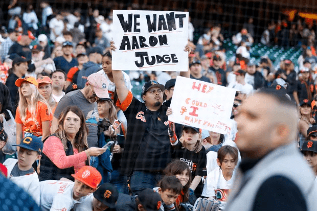 Un aficionado de los Gigantes de San Francisco muestra una pancarta que dice "queremos a Aaron Judge" en el Oracle Park de San Francisco el 2 de octubre de 2022.