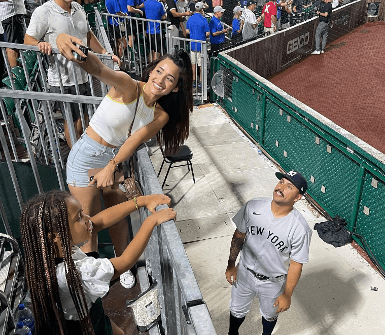 Girlfriend Alondra taking a photo of Nestor Cortes during a Yankee away game.