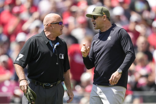 New York Yankees manager Aaron Boone, right, speaks with umpire Brian O'Nora in the first inning of a baseball game against the Cincinnati Reds in Cincinnati, Sunday, May 21, 2023. Boone was ejected by home plate umpire Emil Jimenez.