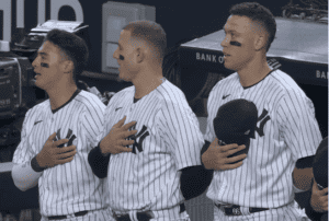 Anthony Volpe, Anthony Rizzo, and Aaron Judge are signing national anthem prior to the Yankees vs. Athletics game at Yankee Stadium on May 9, 2023.