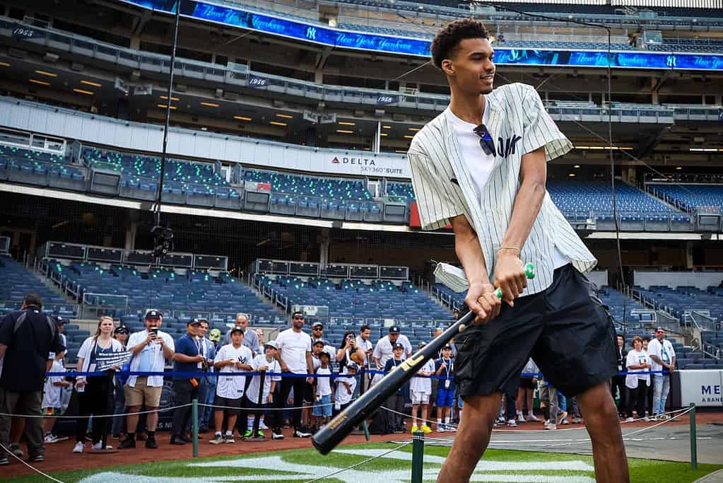 Victor Wembanyama, a projected first round 2023 NBA draft prospect, prepares to hold a bat before a baseball game between the New York Yankees and the Seattle Mariners, Tuesday, June 20, 2023,