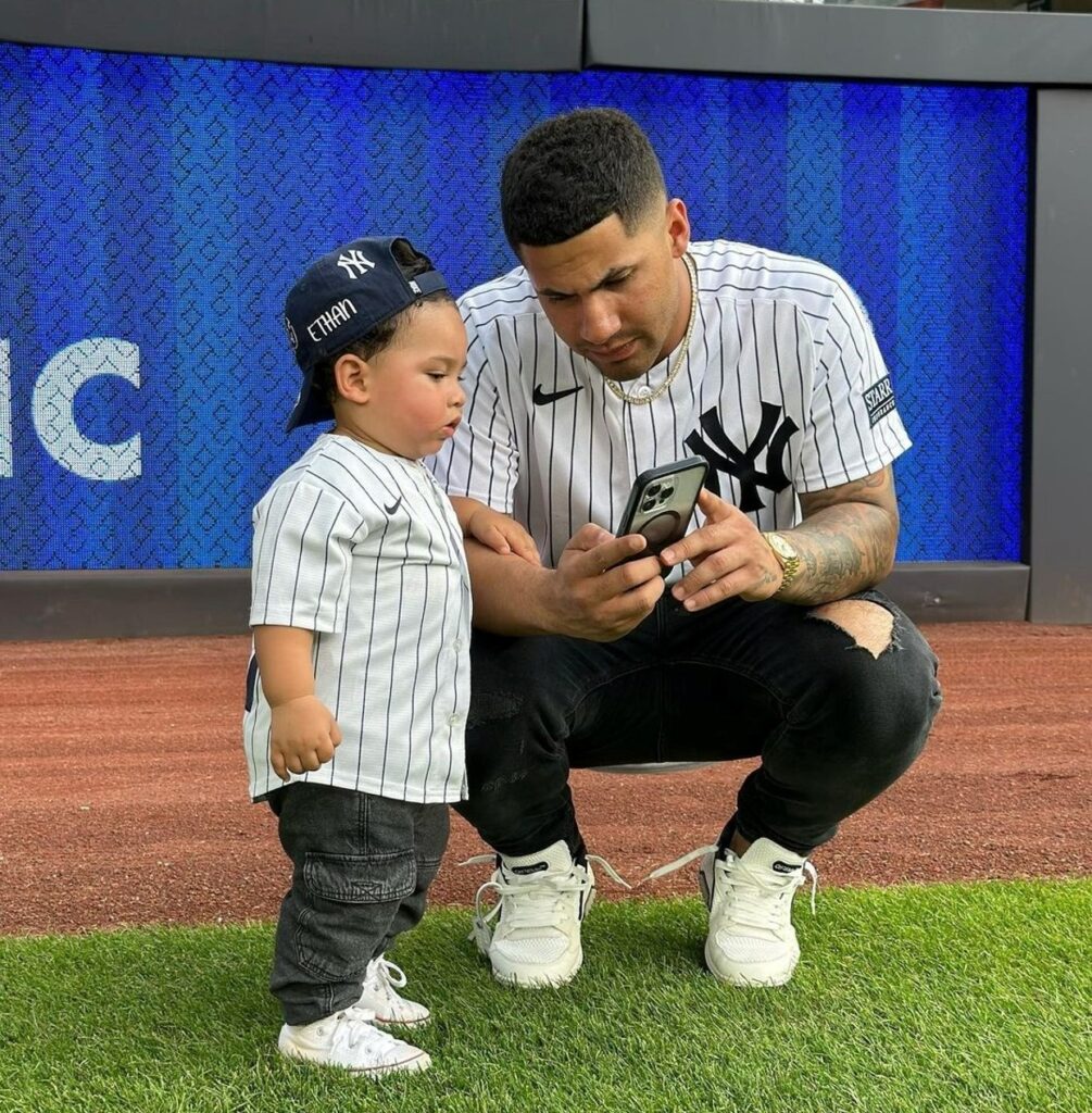 Gleyber Torres and his son watching his mobile at Yankee Stadium.