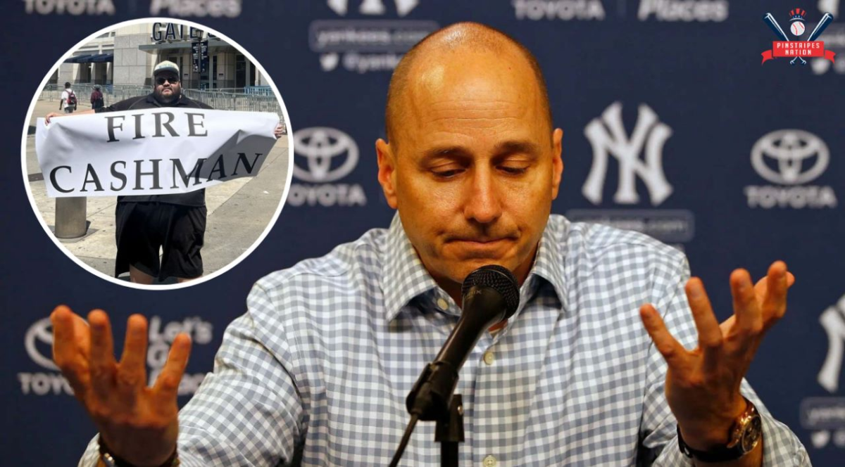 Yankees GM is explaining his trade inaction while fan Jon holds a banner reading "FIRE CASHMAN" outside Yankee Stadium on Aug 1, 2023.