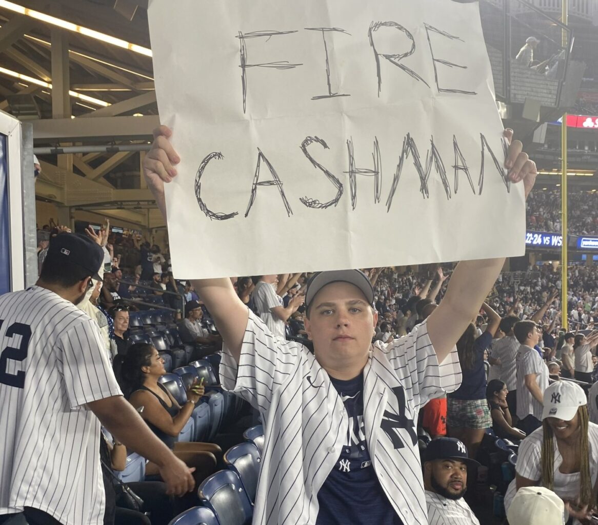 A Yankees fan holds a FIRE CASHMAN sign at Yankee Stadium on August 5, 2023.