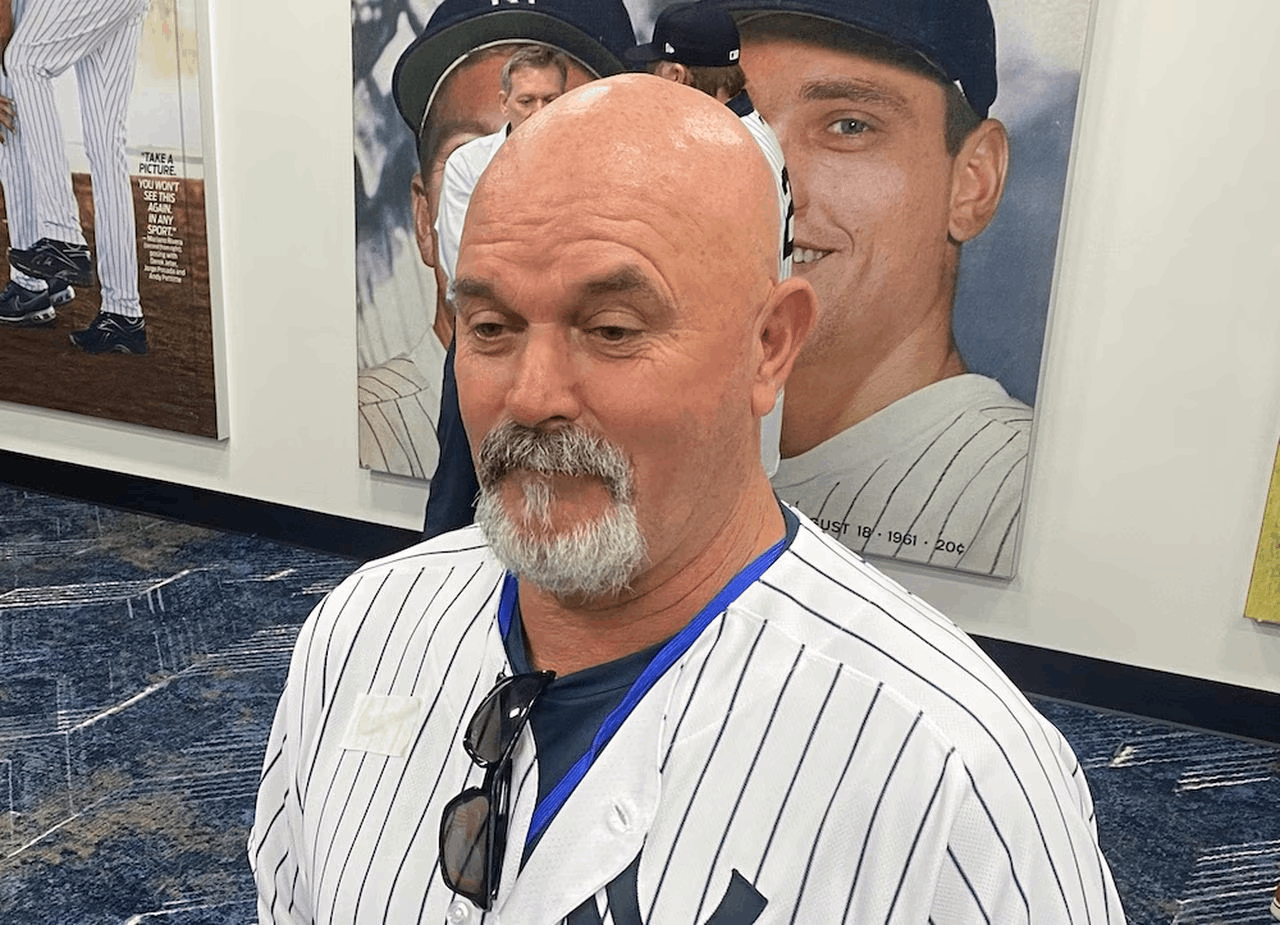 Former Yankees left-hander David Wells defended general manager Brian Cashman while speaking to reporters on Old-Timers' Day at Yankee Stadium.