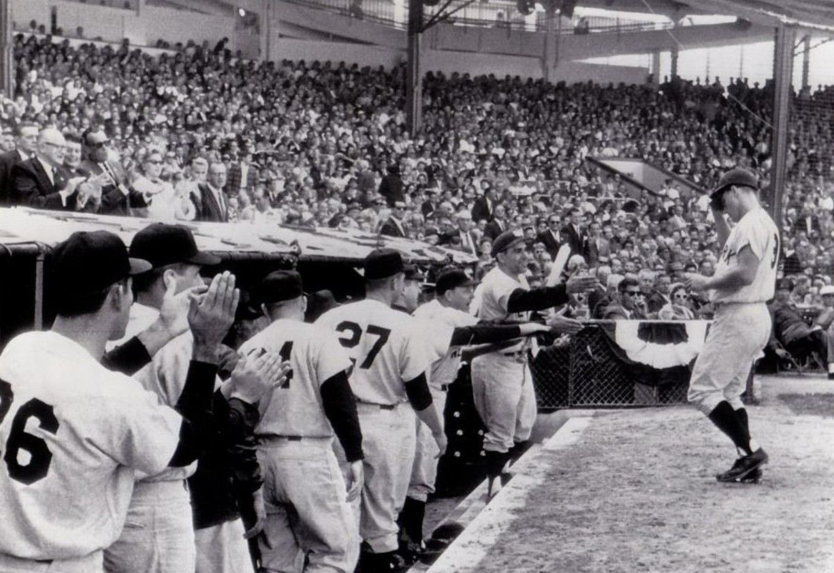 Compañeros de equipo dan la bienvenida a Roger Maris al banquillo de los Yankees después de que conectara un jonrón contra los Reds en el Crosley Field en el segundo partido de las Series Mundiales de 1961 el 7 de octubre de 1961.
