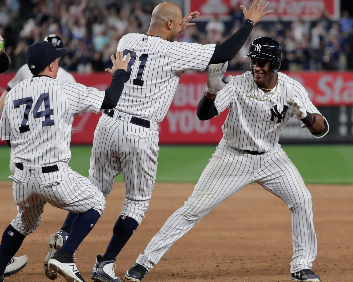 The Yankees’ Miguel Andujar, right, was mobbed by teammates after hitting the winning single against the Cleveland Indians in the ninth inning on May 4, 2018.