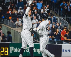 Yankees stars Aaron Judge and Gleyber Torres are celebrating during a win in the 2023 season.