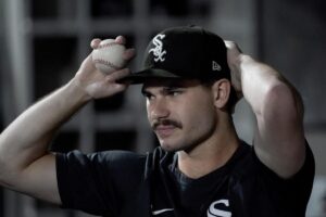 Chicago White Sox starting pitcher Dylan Cease adjusts his cap in the dugout during a baseball game against the Cleveland Guardians Wednesday, Sept. 21, 2022, in Chicago.
