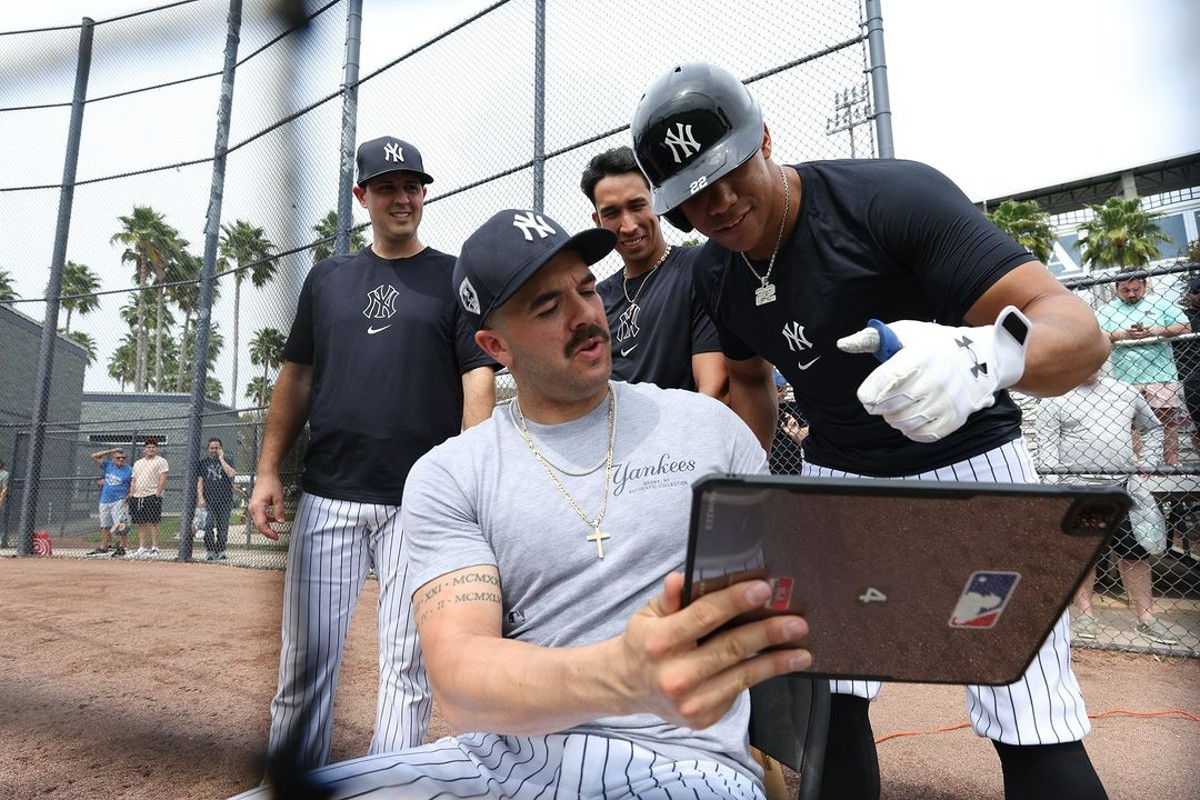 Yankees stars Austin Wells and Juan Soto are looking at a tablet at Tampa, FL, on March 5, 2024.