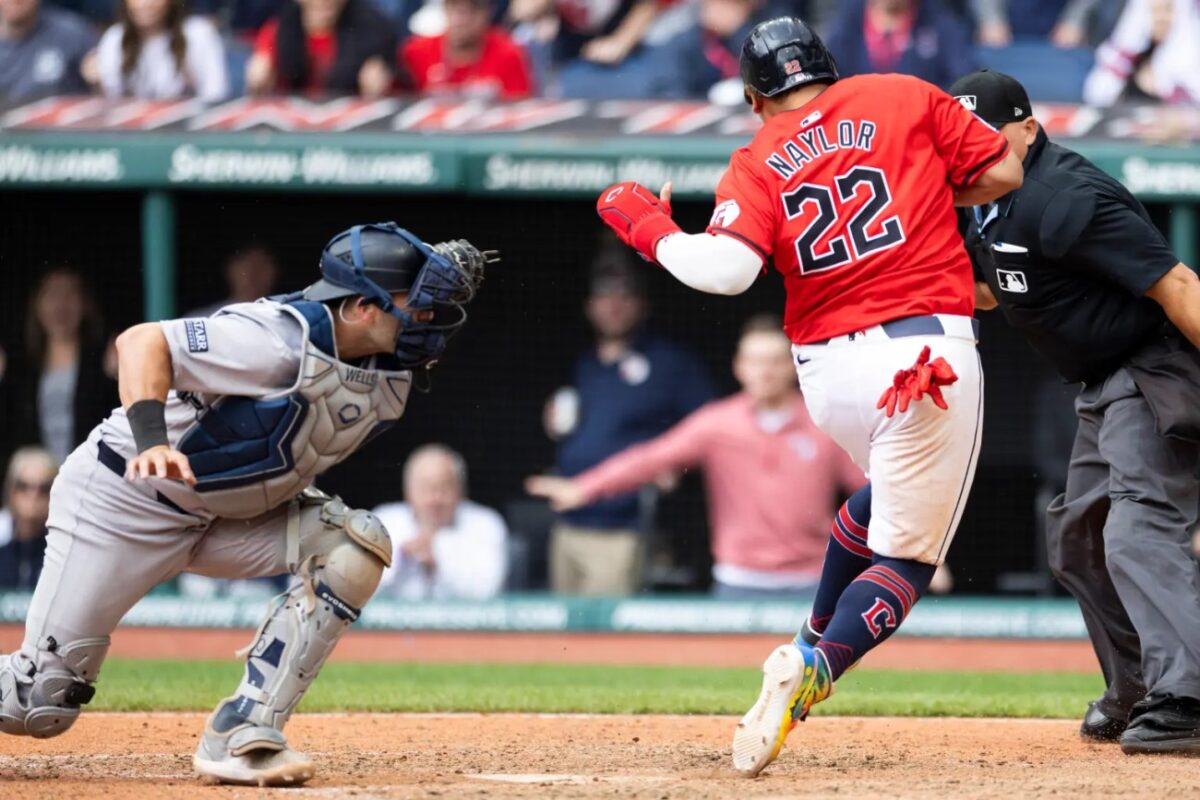 Cleveland Guardians designated hitter Josh Naylor (22) crosses the plate beating the tag by New York Yankees catcher Austin Wells (28) during the tenth inning.