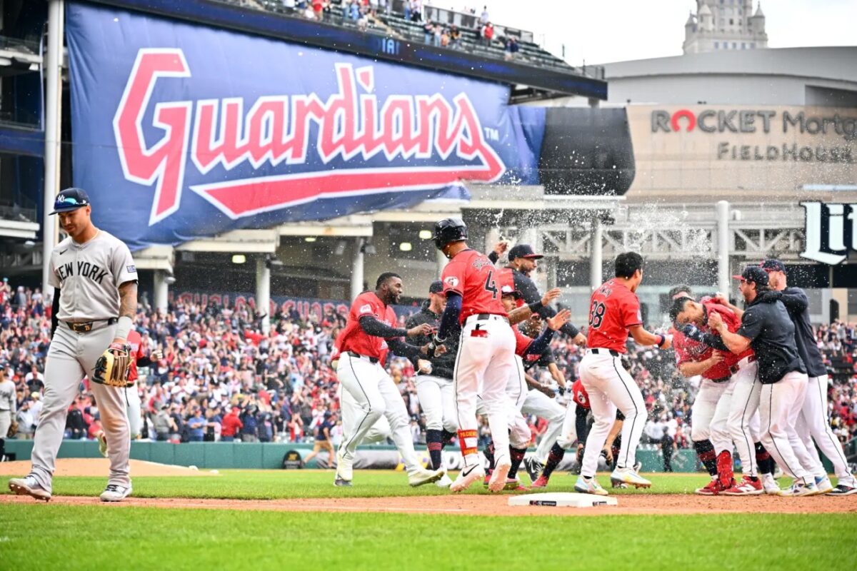 Gleyber Torres #25 of the New York Yankees walks off the field while the Cleveland Guardians celebrate after Andrés Giménez #0 hit a walk-off sacrifice fly to right during the tenth inning at Progressive Field.