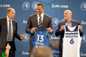 New Minnesota Timberwolves owners Marc Lore, right, and baseball great Alex Rodriguez, center, hold jerseys presented to them by team owner Glen Taylor during a new conference to introduce the new ownership partners of the NBA Timberwolves basketball team and the Minnesota Lynx of the WNBA