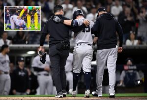 Yankees' manager Aaron Boone and a trainer are helping injured Jon Berti to retun to dugout at Petco Park on May 24, 2024.