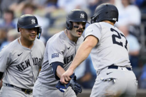 New York Yankees’ Austin Wells, center, is congratulated after his home run drove in Giancarlo Stanton (27) and New York Yankees’ Gleyber Torres, left, during the fourth inning of the team’s baseball game against the Kansas City Royals, Tuesday, June 11, 2024, in Kansas City, Mo.