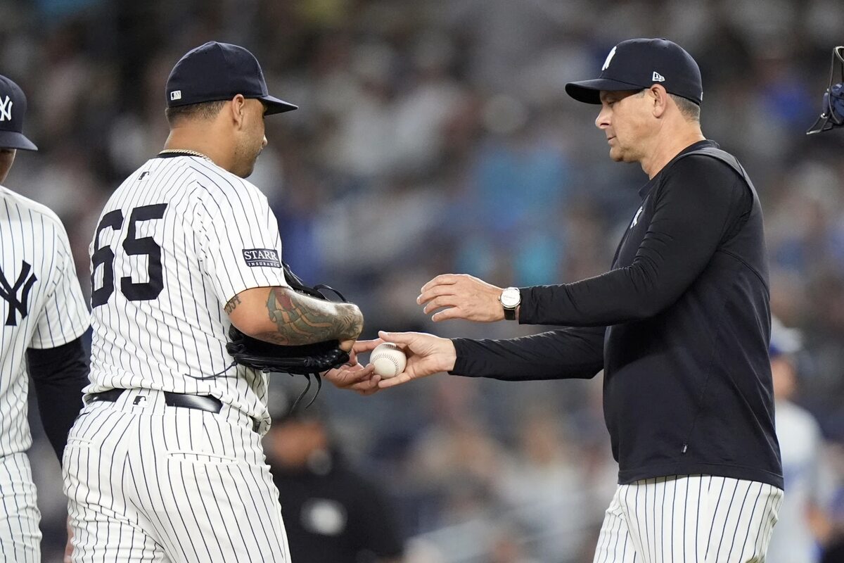 New York Yankees manager Aaron Boone, right, takes the ball from pitcher Nestor Cortes as he leaves during the sixth inning of a baseball game against the Los Angeles Dodgers, Saturday, June 8, 2024, in New York.