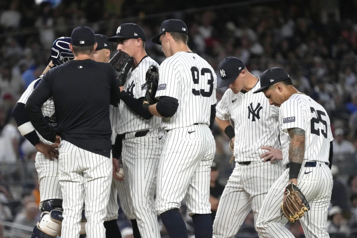 New York Yankees players meet at the pitcher’s mound after Baltimore Orioles’ Ryan Mountcastle walks to first base during the fifth inning of a baseball game, Wednesday, June 19, 2024, in New York. 