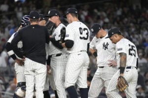 New York Yankees players meet at the pitcher’s mound after Baltimore Orioles’ Ryan Mountcastle walks to first base during the fifth inning of a baseball game, Wednesday, June 19, 2024, in New York.