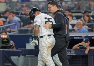 Gleyber Torres of the New York Yankees is being escorted out after an injury on June 20, 2024.