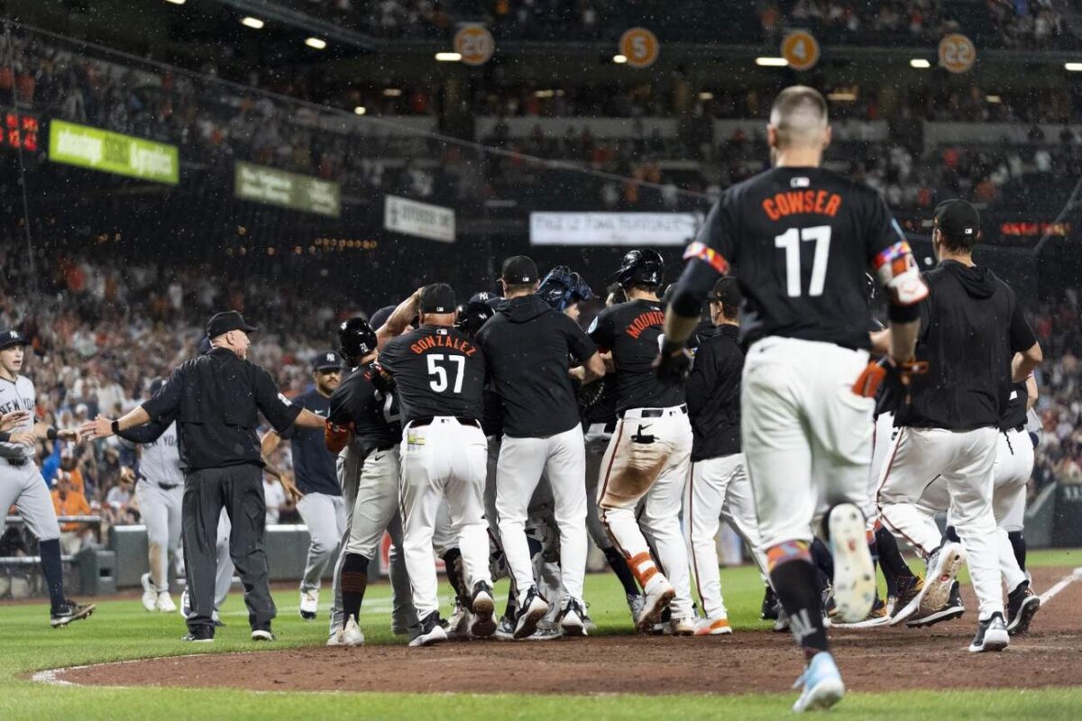 Los jugadores despejan los banquillos después de que Heston Kjerstad, de los Orioles de Baltimore, fuera golpeado por un lanzamiento del relevista de los Yankees de Nueva York Clay Holmes durante la novena entrada de un partido de béisbol, el viernes 12 de julio de 2024, en Baltimore.  