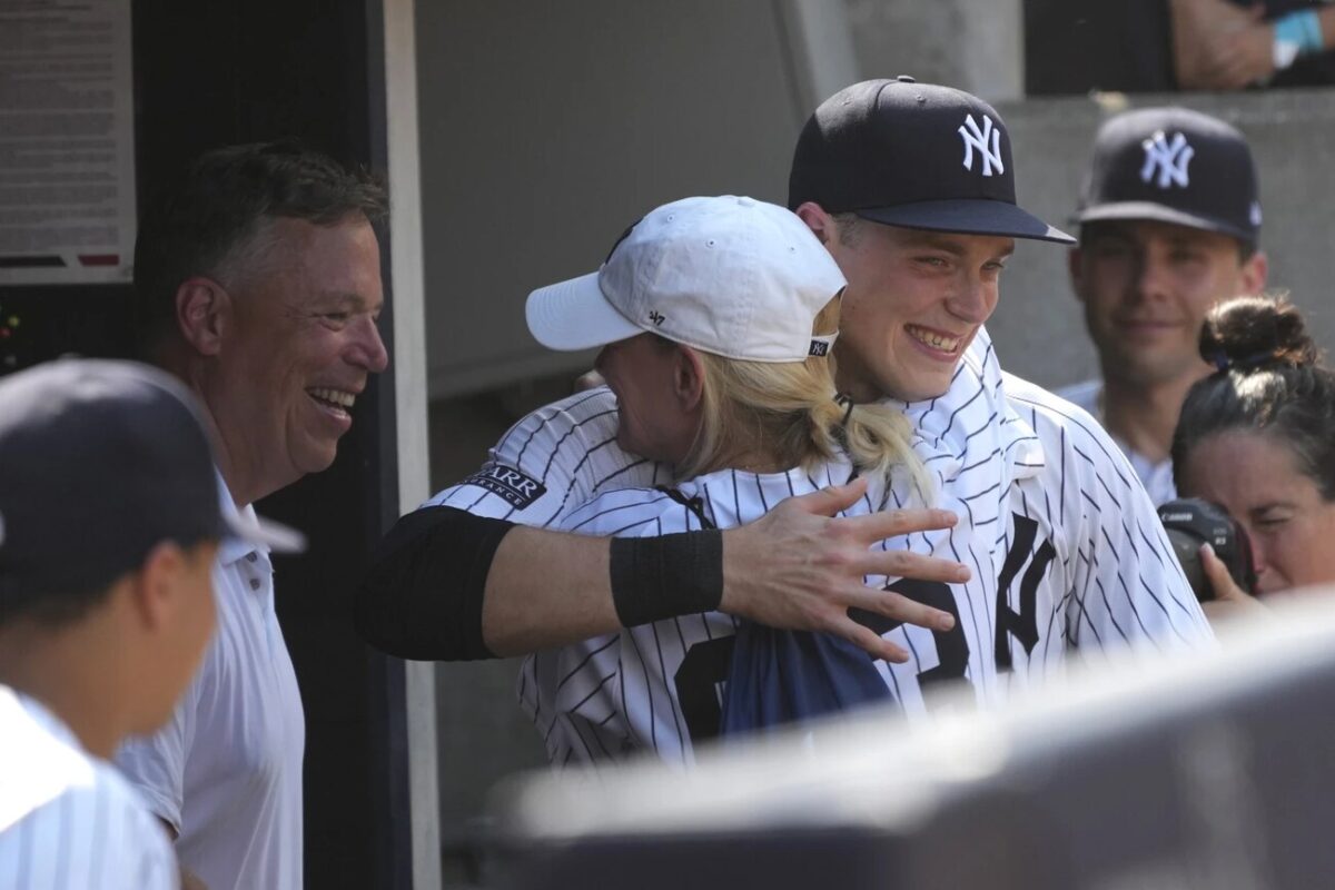 Ben Rice, de los Yankees de Nueva York, en el centro a la derecha, abraza a su familia tras ganar un partido de béisbol contra los Medias Rojas de Boston, el sábado 6 de julio de 2024, en Nueva York.