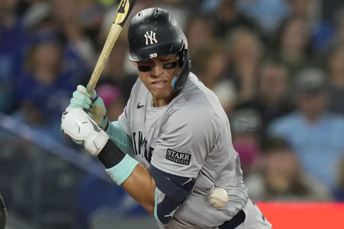 Aaron Judge, de los New York Yankees, es golpeado por un lanzamiento durante la cuarta entrada de un partido de béisbol contra los Toronto Blue Jays en Toronto, el domingo 30 de junio de 2024.