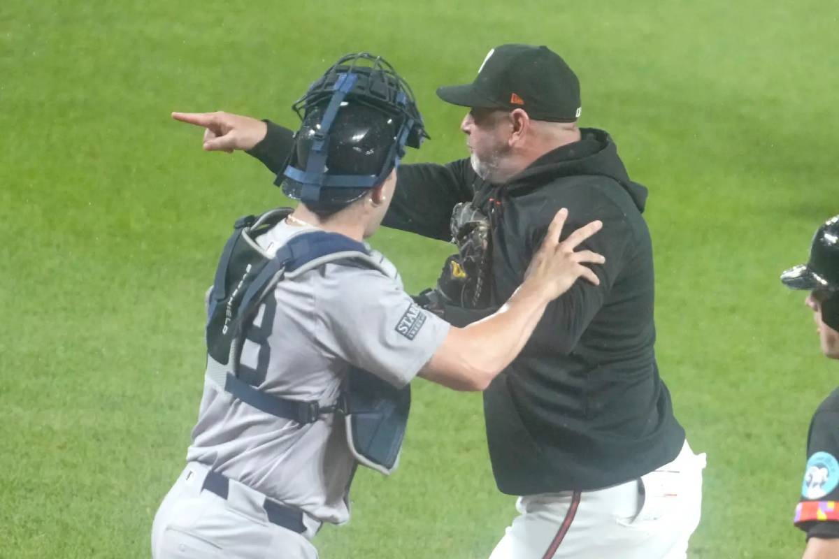 El catcher Austin Wells (izq.) retiene al manager de los Orioles, Brandon Hyde, durante la victoria de los Yankees sobre los Orioles el 12 de julio de 2024.