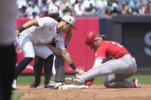 Cincinnati Reds’ Jake Fraley, right, steals second base as New York Yankees second baseman Gleyber Torres attempts to tag him out during the fourth inning of a baseball game, Thursday, July 4, 2024, in New York.