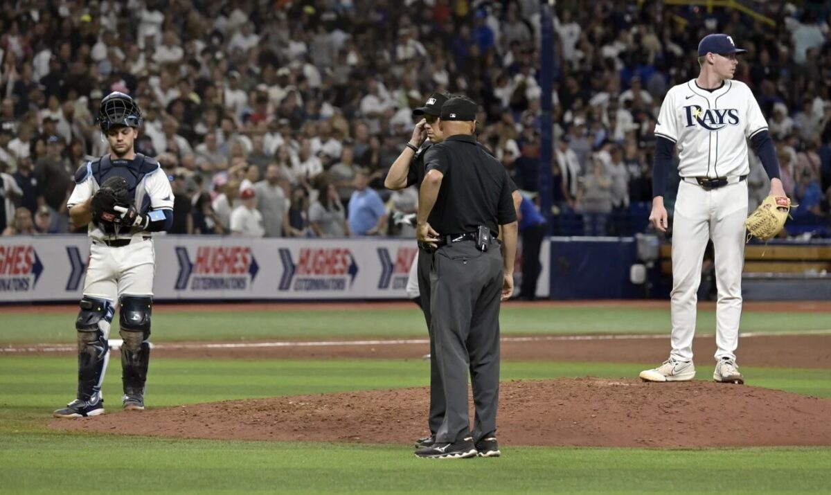 Tampa Bay Rays catcher Ben Rortvedt, left, and closer Pete Fairbanks, right, wait as umpires rule on a challenge made by the New York Yankees on the final play in the ninth inning of a baseball game Thursday, July 11, 2024, in St. Petersburg, Fla.