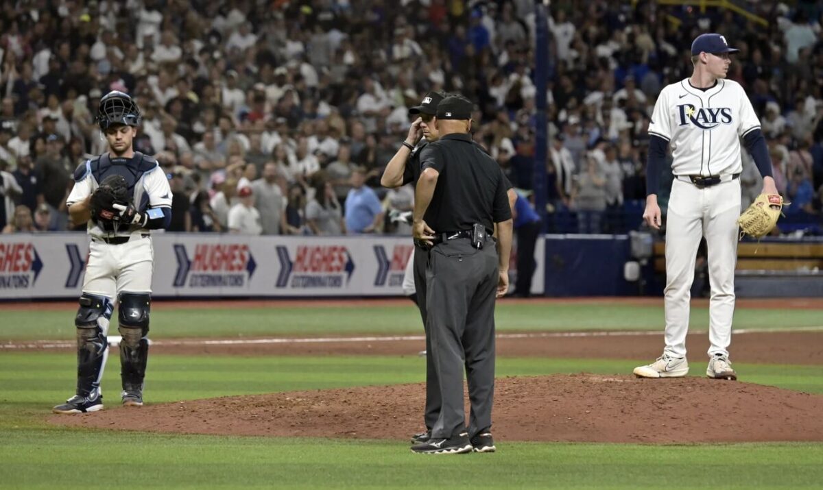 El receptor de los Tampa Bay Rays Ben Rortvedt, izquierda, y el cerrador Pete Fairbanks, derecha, esperan mientras los árbitros deciden sobre un desafío realizado por los New York Yankees en la última jugada de la novena entrada de un partido de béisbol el jueves 11 de julio de 2024, en San Petersburgo, Florida.