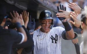 New York Yankees’ Aaron Judge is greeted in the dugout after hitting a home run in the seventh inning of a baseball game against the Texas Rangers, Sunday, Aug. 11, 2024, in New York.