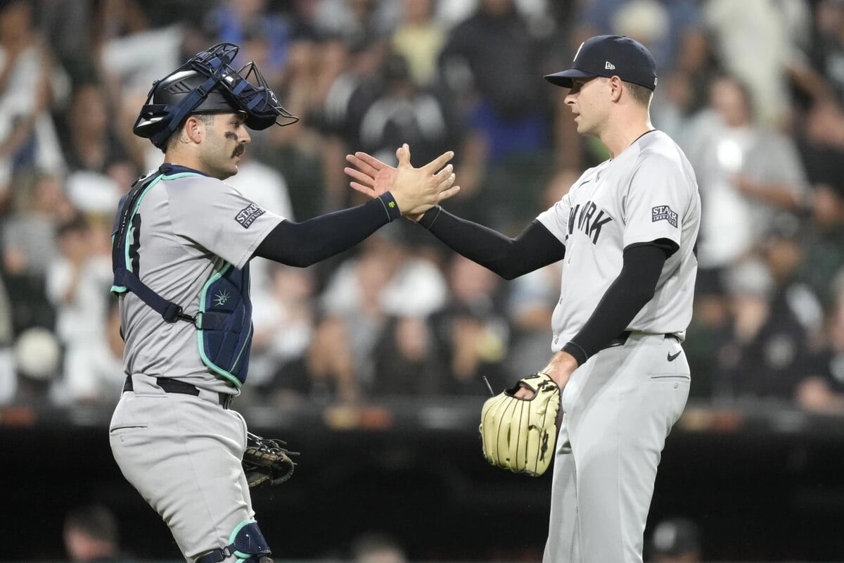 El receptor de los Yankees de Nueva York Austin Wells, izquierda, y el lanzador relevista Jake Cousins celebran la victoria del equipo por 4-1 sobre los Medias Blancas de Chicago en un partido de béisbol el martes 13 de agosto de 2024, en Chicago.