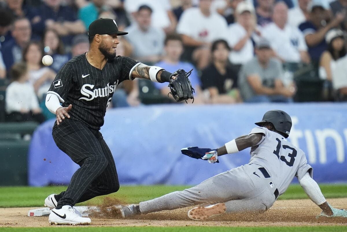 Jazz Chisholm Jr. de los Yankees de Nueva York, a la derecha, se desliza a salvo hacia la tercera base mientras el tercera base de los Medias Blancas de Chicago, Lenyn Sosa, pierde la bola durante la segunda entrada de un partido de béisbol el lunes 12 de agosto de 2024, en Chicago.