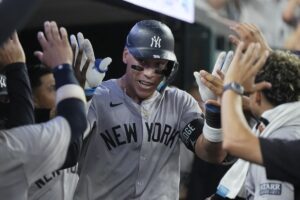 New York Yankees’ Aaron Judge is greeted in the dugout after a solo home run during the eighth inning of a baseball game against the Detroit Tigers, Friday, Aug. 16, 2024, in Detroit.