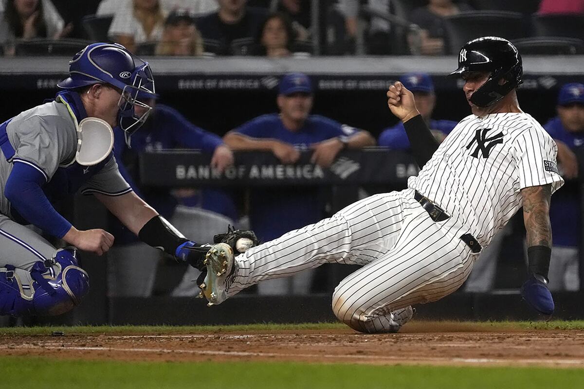 Gleyber Torres, de los Yankees de Nueva York, a la derecha, es eliminado en el home plate por el receptor de los Blue Jays de Toronto Brian Serven, a la izquierda, durante la segunda entrada de un partido de béisbol, el viernes 2 de agosto de 2024, en Nueva York.