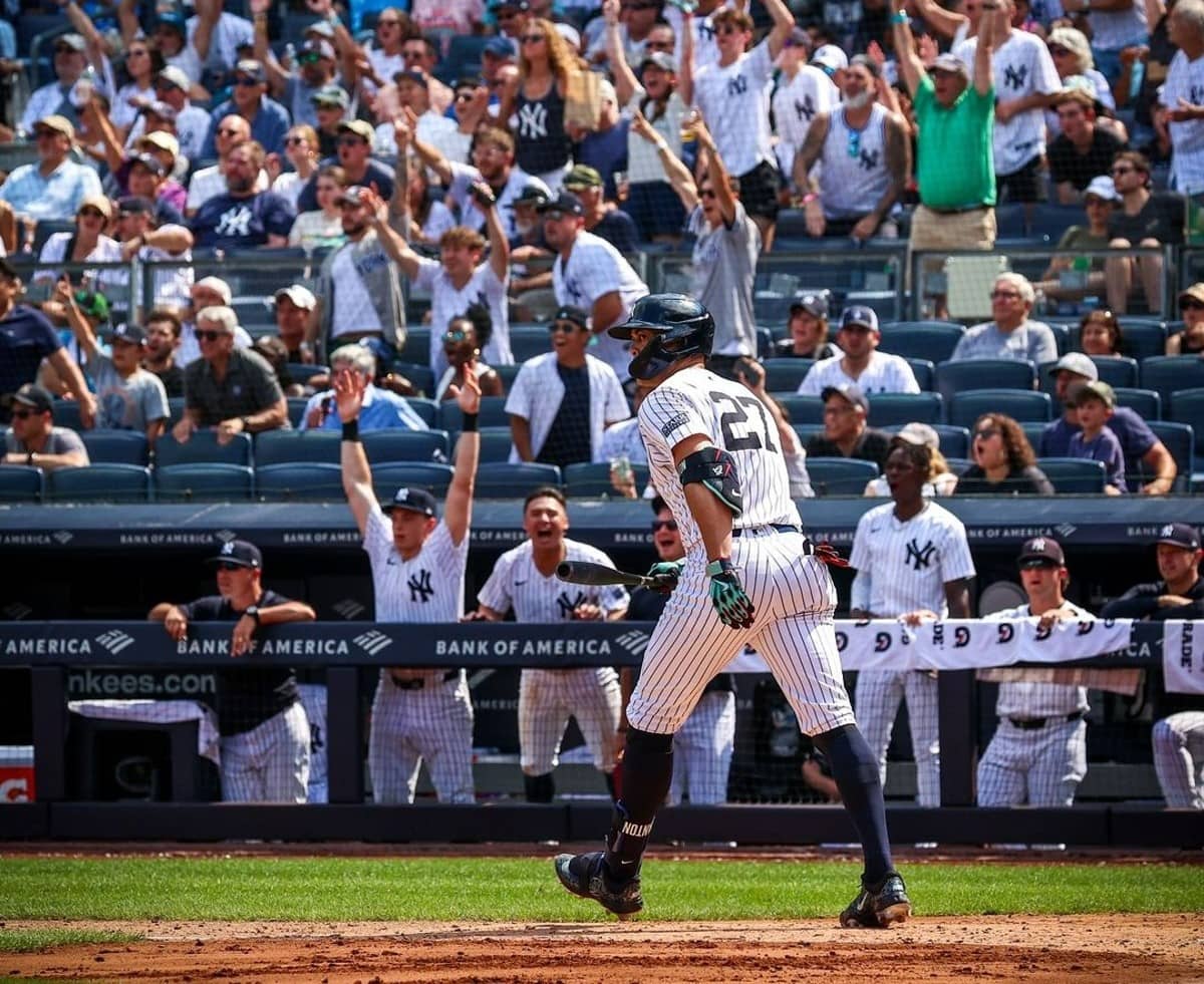 New York Yankees fans and dugout erupt in joy after Giancarlo Stanton hits a home run in the fifth inning against the Texas Rangers, Sunday, Aug. 11, 2024, in New York.