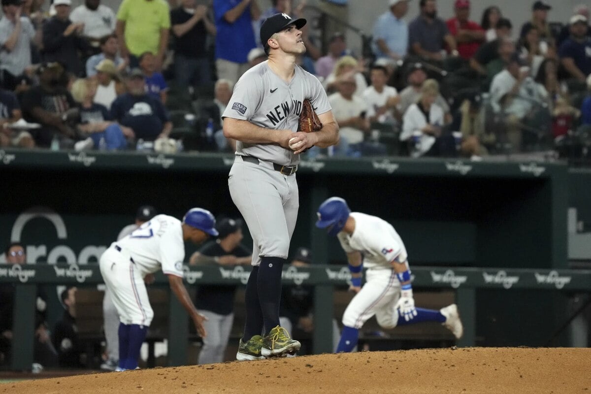 New York Yankees starting pitcher Carlos Rodon walks back up the mound after giving up a solo home run to Texas Rangers’ Josh Jung as Jung celebrates with third base coach Tony Beasley during the fourth inning of a baseball game, Tuesday, Sept. 3, 2024, in Arlington, Texas.