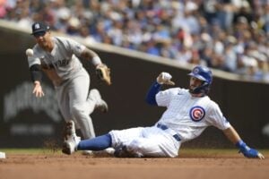 Chicago Cubs’ Dansby Swanson, right, slides safely into second as New York Yankees second baseman Gleyber Torres, left, commits a throwing error during the first inning of a baseball game in Chicago, Sunday, Sept. 8, 2024.