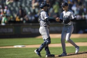 New York Yankees catcher Austin Wells, left, celebrates a win with pitcher Luke Weaver after a baseball game against the Oakland Athletics in Oakland, Calif., Sunday, Sept. 22, 2024.