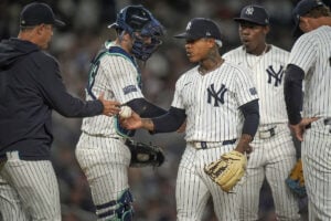 New York Yankees pitcher Marcus Stroman (0) hands the ball off to manager Aaron Boone (17) as he exits the game during the fourth inning of a baseball game against the Baltimore Orioles, Wednesday, Sept. 25, 2024, in New York.