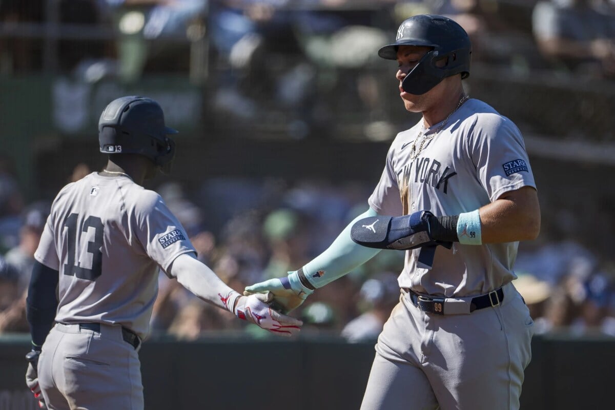 Jazz Chisholm Jr. (13) de los Yankees de Nueva York celebra con Aaron Judge (derecha) después de que anotara durante la séptima entrada de un partido de béisbol contra los Atléticos de Oakland en Oakland, California, el domingo 22 de septiembre de 2024.