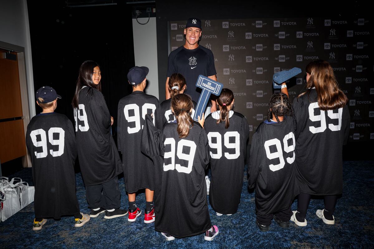 Yankees' Aaron Judge and fans wearing his no. 99 shirts at a 2024 charity event.