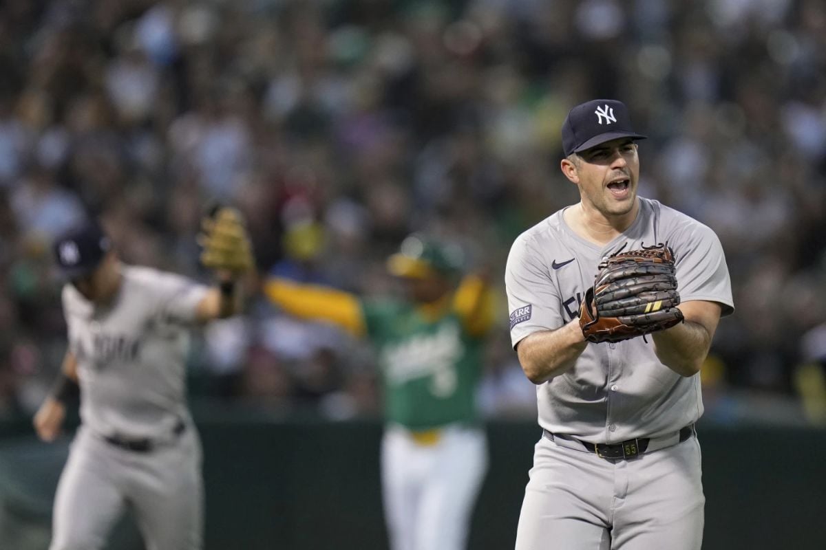 El lanzador de los Yankees de Nueva York Carlos Rodón, a la derecha, reacciona después de que el campocorto Anthony Volpe lanzara fuera a Brent Rooker, de los Atléticos de Oakland, en la primera base para poner fin a la tercera entrada de un partido de béisbol el sábado 21 de septiembre de 2024, en Oakland, California.