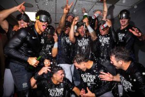 New York Yankees players celebrate in the clubhouse after clinching their 2024 postseason berth, marking the team's entry into October baseball and their quest for a 28th championship