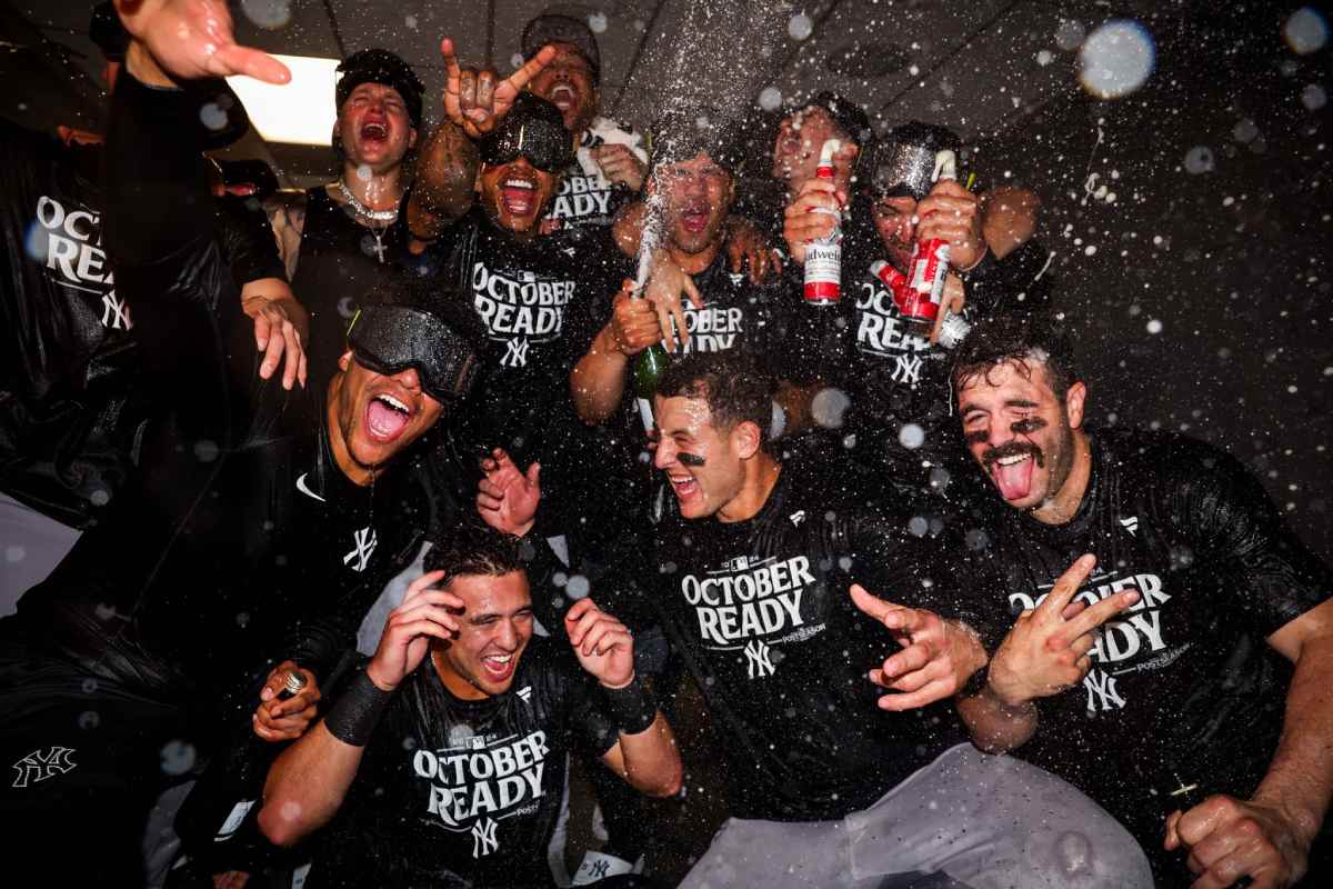 Yankees players celebrated in the clubhouse after securing a postseason berth with their win over the Mariners, as they looked forward to the playoffs.