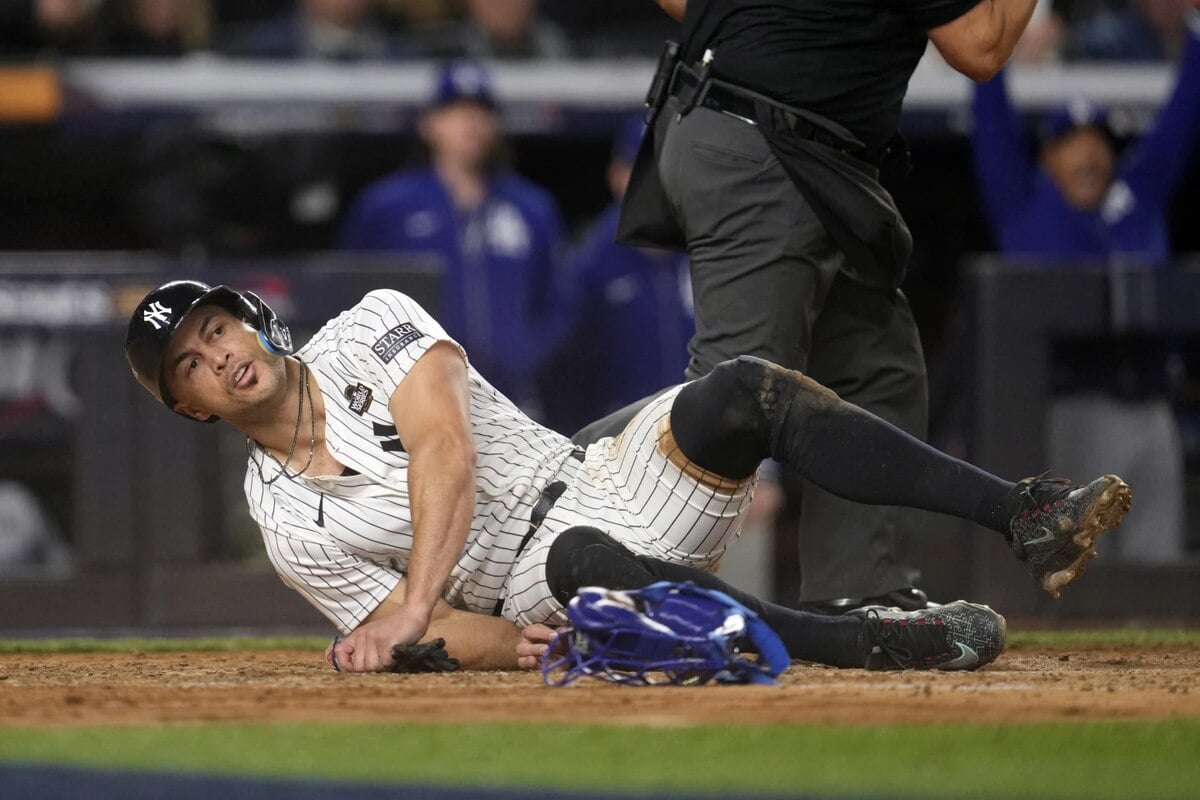 New York Yankees’ Giancarlo Stanton lies on the ground after being tagged out while trying to score against the Los Angeles Dodgers during the fourth inning in Game 3 of the baseball World Series, Monday, Oct. 28, 2024, in New York. 