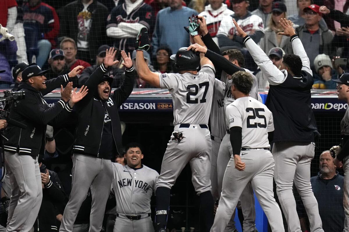 Giancarlo Stanton (27), de los Yankees de Nueva York, celebra con sus compañeros tras batear un jonrón contra los Guardianes de Cleveland durante la octava entrada del tercer partido de la Serie de Campeonato de la Liga Americana de Béisbol, el jueves 17 de octubre de 2024, en Cleveland.