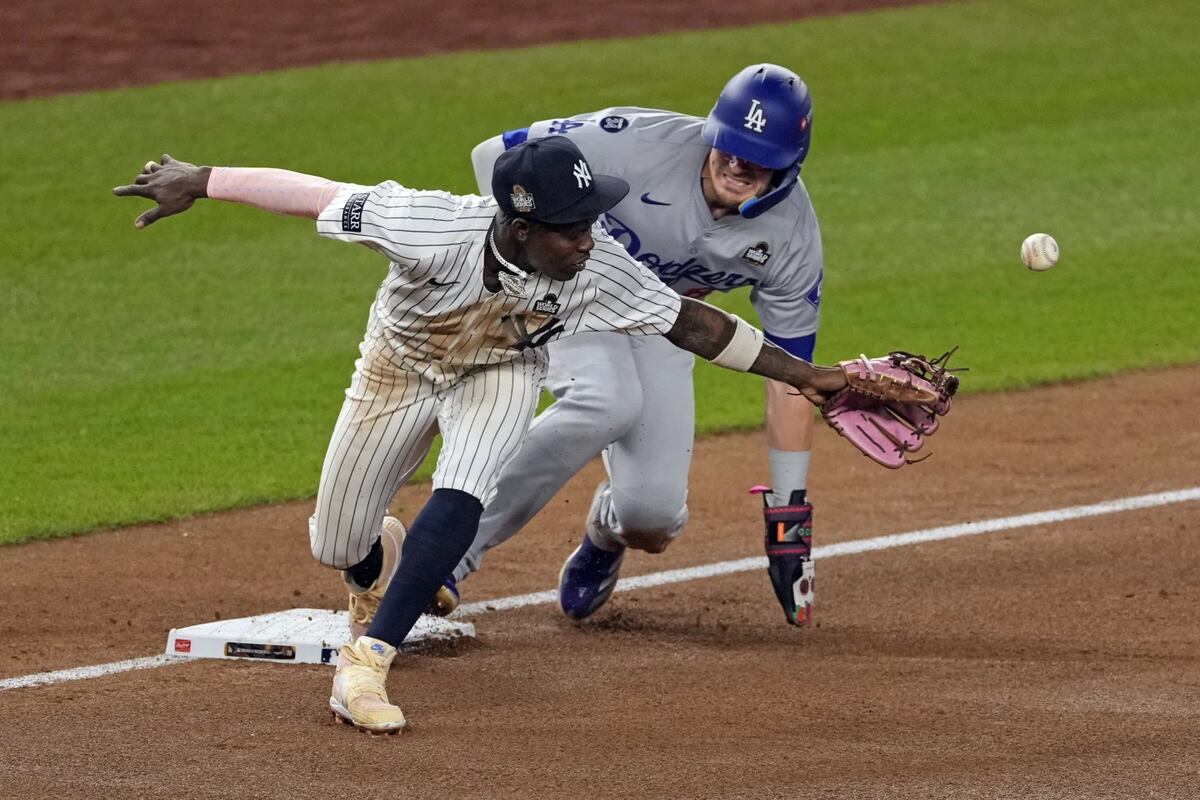 Los Angeles Dodgers’ Kiké Hernández, right, is safe at third as New York Yankees third baseman Jazz Chisholm Jr. reaches for a throw from shortstop Anthony Volpe during the fifth inning in Game 5 of the baseball World Series, Wednesday, Oct. 30, 2024, in New York. Volpe was charged with a throwing error.